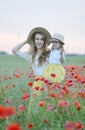 Cute little girl with her mother walking in the field with poppies flowers Royalty Free Stock Photo