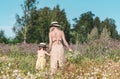 Cute little girl with her mother walking in the flowers field Royalty Free Stock Photo