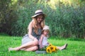 Cute little girl with her mother walking in the park, sunflowers Royalty Free Stock Photo