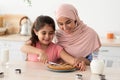 Cute Little Girl And Her Muslim Mother Cutting Homemade Pie In Kitchen Royalty Free Stock Photo