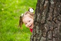 Cute little girl hiding behind huge tree Royalty Free Stock Photo