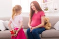 Girl hiding gift from mother behind her back