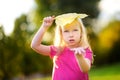 Cute little girl holding big yellow leaf above her head Royalty Free Stock Photo