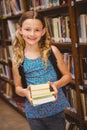 Cute little girl holding books in library Royalty Free Stock Photo