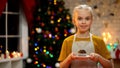 Cute little girl holding chocolate muffin and smiling, wishing Merry Christmas Royalty Free Stock Photo