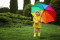 Cute little girl holding colorful umbrella in garden, space for text Royalty Free Stock Photo