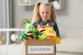 Cute little girl holding donation box with soft toys at home Royalty Free Stock Photo