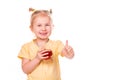 Cute little girl holding glass with juice smiling with her thumb up Royalty Free Stock Photo