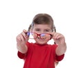 Cute little girl holding glasses and looking thru it