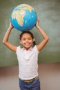 Cute little girl holding globe over head Royalty Free Stock Photo