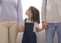 Cute Little Girl Holding Hands With Parents, Looking Up To Mom