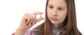 A cute little girl is holding a recently removed molar in her hand. Studio photo on a white background