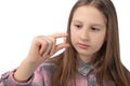 A cute little girl is holding a recently removed molar in her hand. Studio photo on a white background