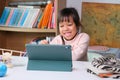Cute little girl holding a Stylus pen working on a tablet. Child using digital tablet searching information on internet for her Royalty Free Stock Photo