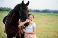 Cute little girl on a horse in a summer field dress. sunny day Royalty Free Stock Photo