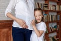 Cute little girl hugging belly of her pregnant mother, listening Royalty Free Stock Photo