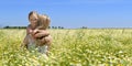 Cute little girl hugging her mom on the flowery meadow Royalty Free Stock Photo