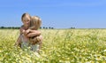 Cute little girl hugging her mom on the flowery meadow Royalty Free Stock Photo