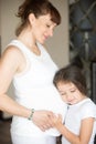 Cute little girl hugging her mother belly Royalty Free Stock Photo