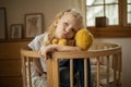 Cute little girl hugging teddy bear smiling while sitting on her bed at home Royalty Free Stock Photo