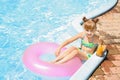 Cute little girl with inflatable ring drinking juice in swimming pool Royalty Free Stock Photo