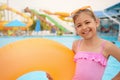 Cute little girl with inflatable ring near pool in water park Royalty Free Stock Photo