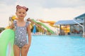 Cute little girl with inflatable ring near pool in water park, space for text Royalty Free Stock Photo