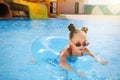 Cute little girl with inflatable ring in pool at water park Royalty Free Stock Photo