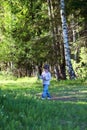 Cute little girl in jeans walking in woods Royalty Free Stock Photo