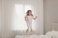 Cute little girl jumping on bed at home Royalty Free Stock Photo