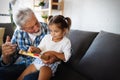 Cute little girl playing with her grandfather at home. Happy family concept Royalty Free Stock Photo