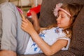 Cute girl kid using iPad digital computer tablet on bed for education or playing game. Royalty Free Stock Photo