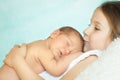 Cute little girl kissing her sleeping newborn sister Royalty Free Stock Photo