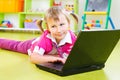 Cute little girl with laptop on floor Royalty Free Stock Photo