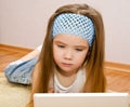 Little girl with a laptop at home on the floor Royalty Free Stock Photo