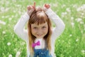 Cute little girl laughing and playing with her hands representing a goat on the green meadow outdoor, happy childhood concept Royalty Free Stock Photo