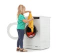 Cute little girl with laundry near washing machine Royalty Free Stock Photo