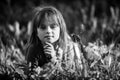 Cute little girl laying in the grass. Black and white photo. Royalty Free Stock Photo