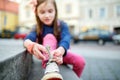 Cute little girl learning to tie shoelaces outdoors Royalty Free Stock Photo