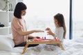 Cute little girl learns to paint her nails by applying polish on mother hands. Royalty Free Stock Photo