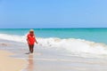 Cute little girl in life jacket on summer beach, safety