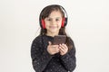 A cute little girl is listening to music using headphones Royalty Free Stock Photo