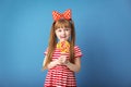 Cute little girl with lollipop on color background Royalty Free Stock Photo