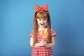 Cute little girl with lollipop on color background Royalty Free Stock Photo