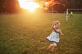 Cute little girl with long hair running with kite in the field on summer sunny day