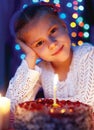 Cute little girl looking at cake with a candle Royalty Free Stock Photo