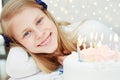 Cute little girl looking at cake with candles. Royalty Free Stock Photo