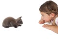 Cute little girl looking at grey kitten lying on floor Royalty Free Stock Photo