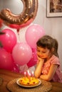 Cute little girl looking at her birthday cake Royalty Free Stock Photo