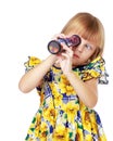 A little girl looks into a telescope or in a kaleidoscope. Royalty Free Stock Photo